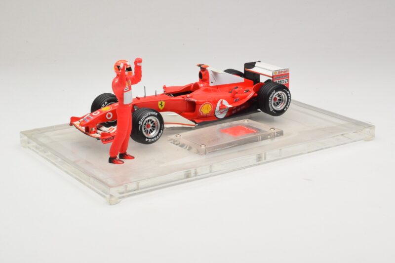 Ferrari F2004 #1 M. Schumacher F1 World Champion 2004 Su Lenktyniniu Kostiumu Hot Wheels 1:18 B66221 Metalas