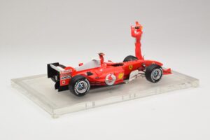 Ferrari F2004 #1 M. Schumacher F1 World Champion 2004 Su Lenktyniniu Kostiumu Hot Wheels 1:18 B66221 Metalas - nuotrauka 2 iš 6