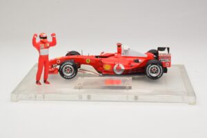 Ferrari F2004 #1 M. Schumacher F1 World Champion 2004 Su Lenktyniniu Kostiumu Hot Wheels 1:18 B66221 Metalas - nuotrauka 3 iš 6